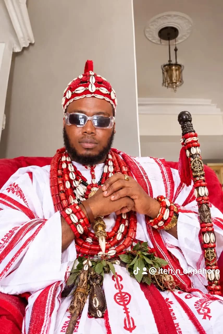 Dr. Iteh N Okpẹhoro in red and white ceremonial regalia with coral beads and cowrie crown